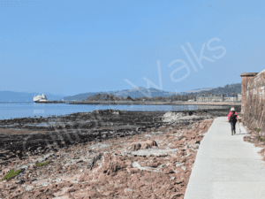smooth concrete walkway right beside a red sandstone beach