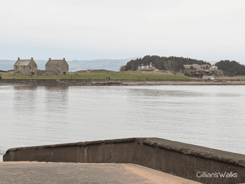 Looking south along the coast from Prestwick Promenade towards two identical brick 'houses' each with two chimneys - the former salt pans.