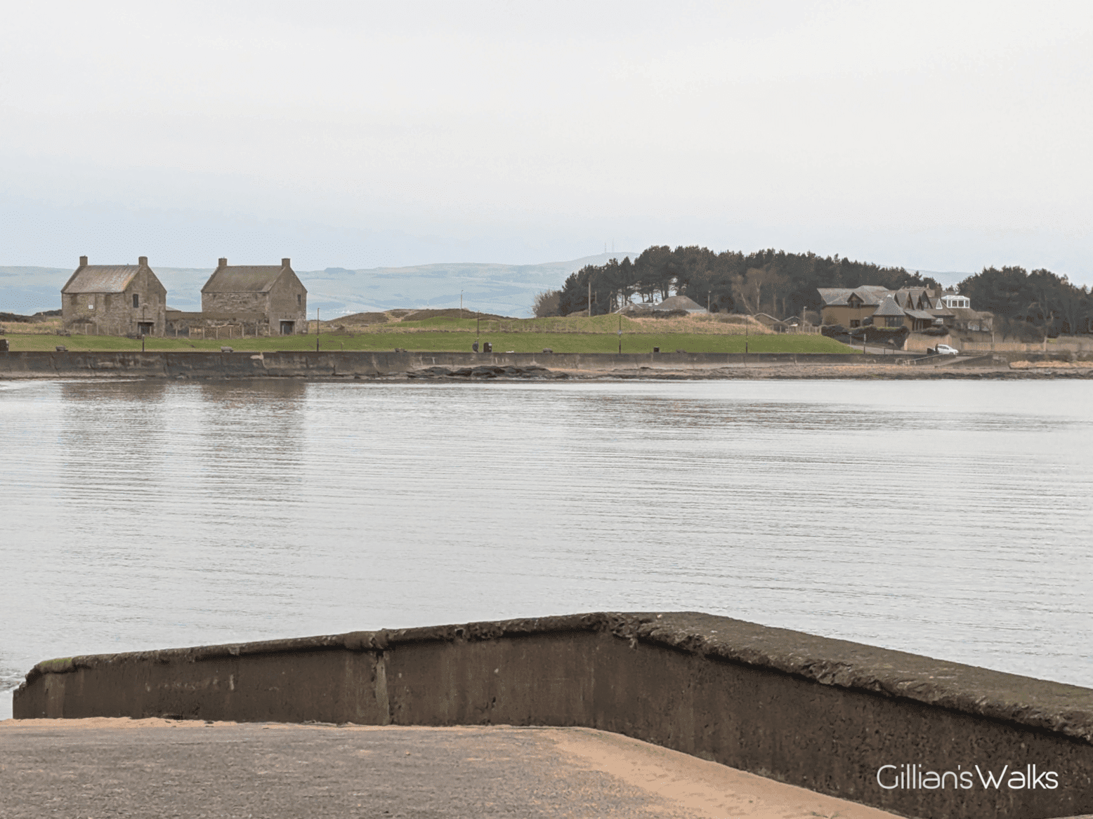 Looking south along the coast from Prestwick Promenade towards two identical brick 'houses' each with two chimneys - the former salt pans.
