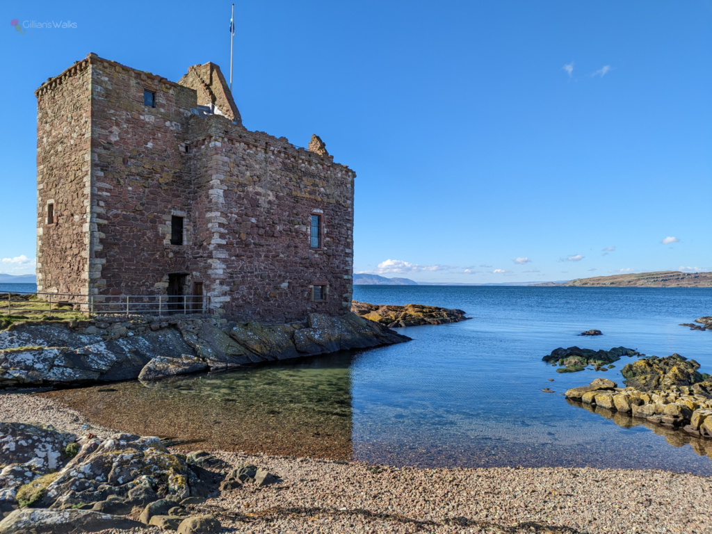 Portencross Castle against a backdrop of clear blue skies and surrounded by crystal clear sea water