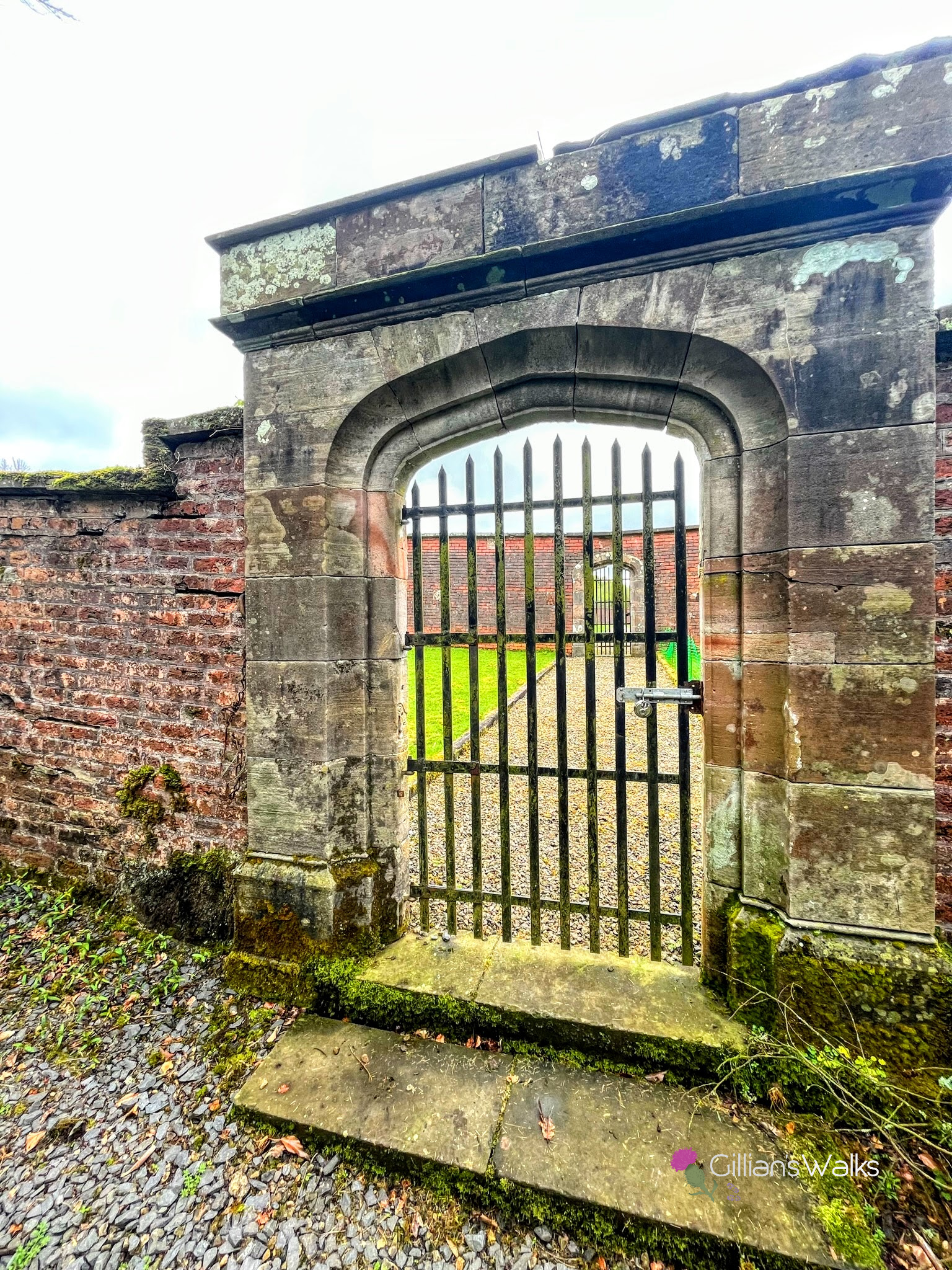 Gated entrance to walled garden, with visibility behind the gate into the garden itself