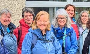 Shelagh surrounded by fellow walkers posing for a photo at the start of a group walk