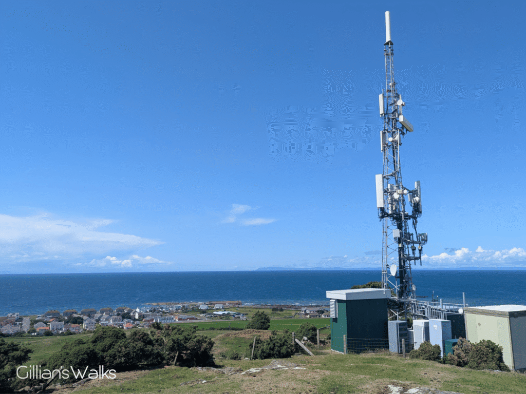 A panoramic seascape seen from a viewpoint beside a tv aerial mast.