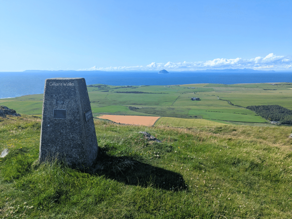 Trig point at the top of Knockdolian with clear views out to Ailsa Craig