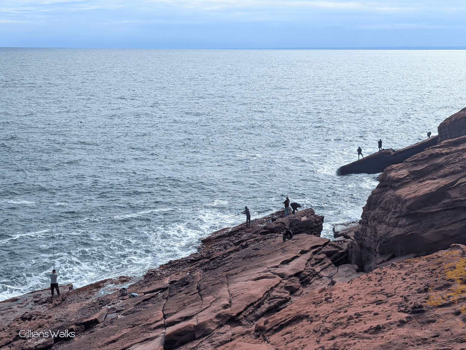 Group of people fishing off the rocks
