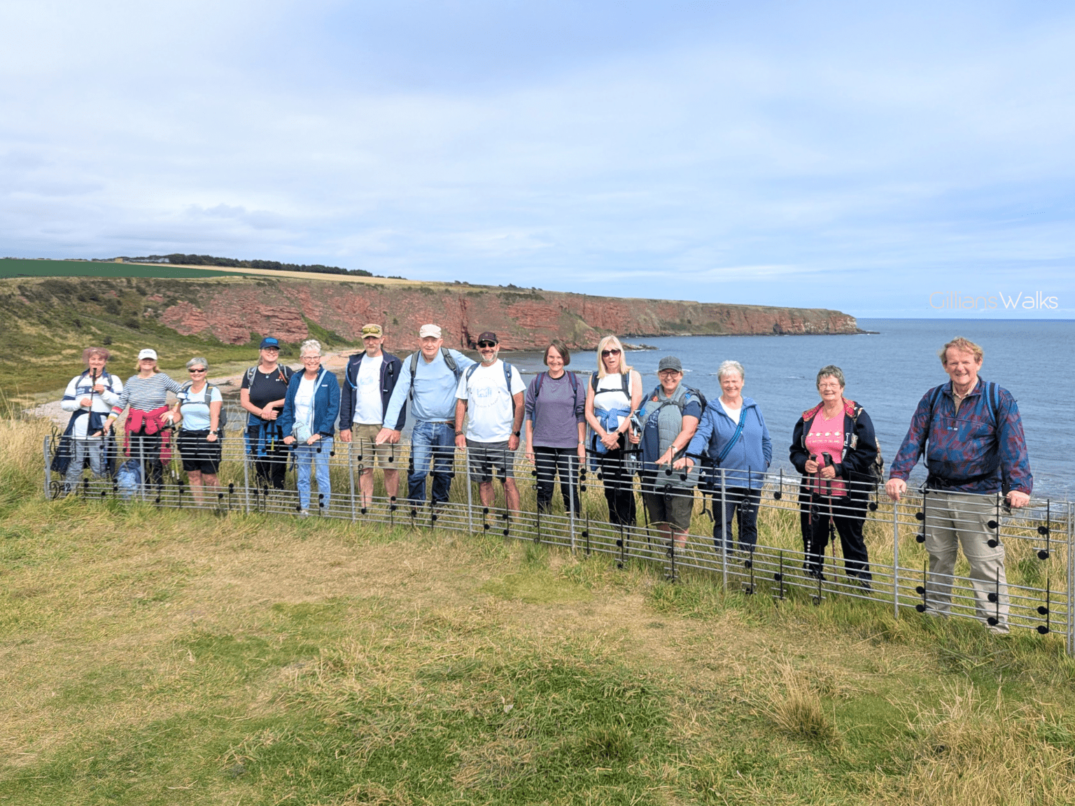 Group photo with everyone standing behind the long music note sculpture