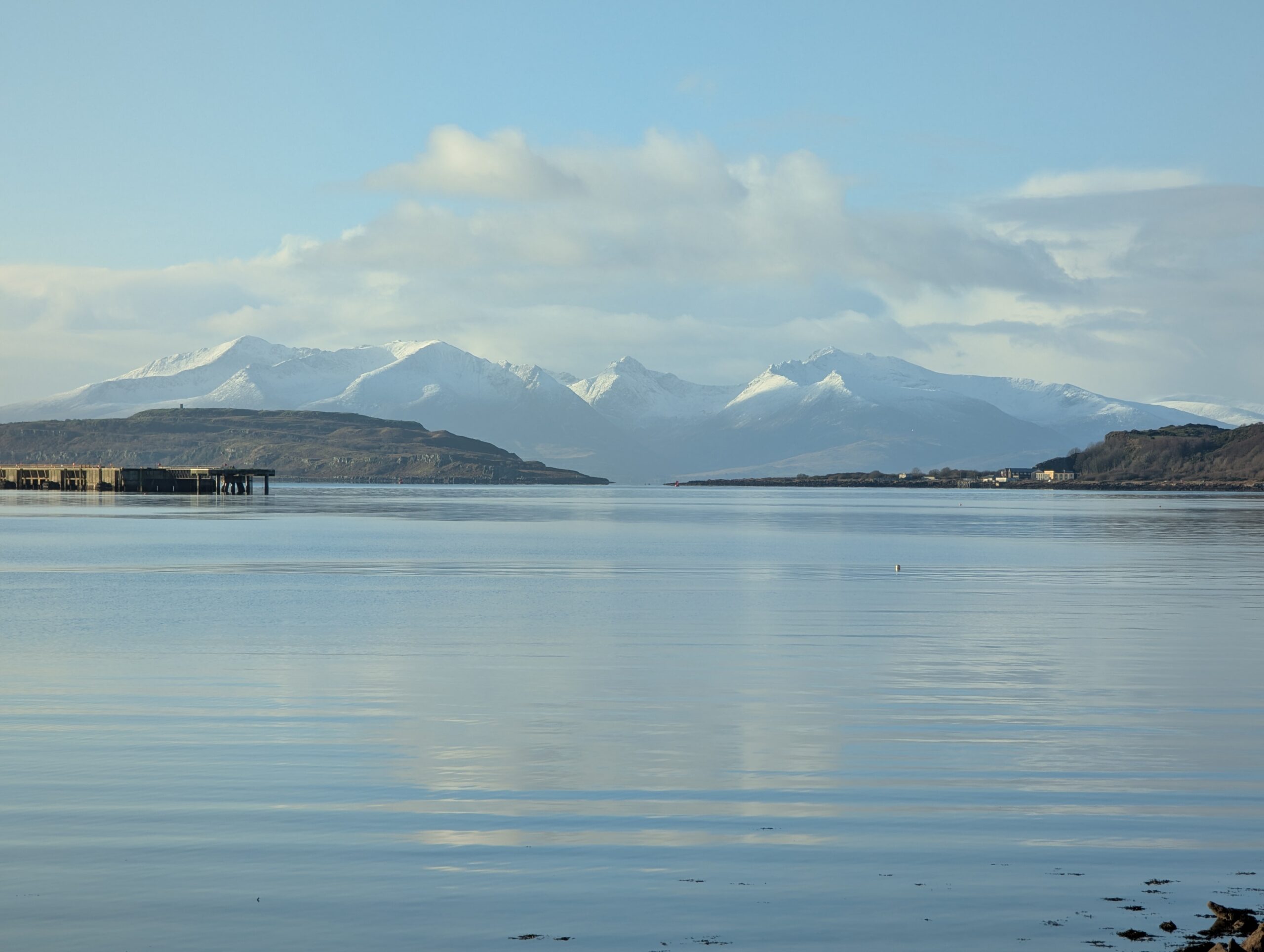 Snow capped mountains across a calm sea