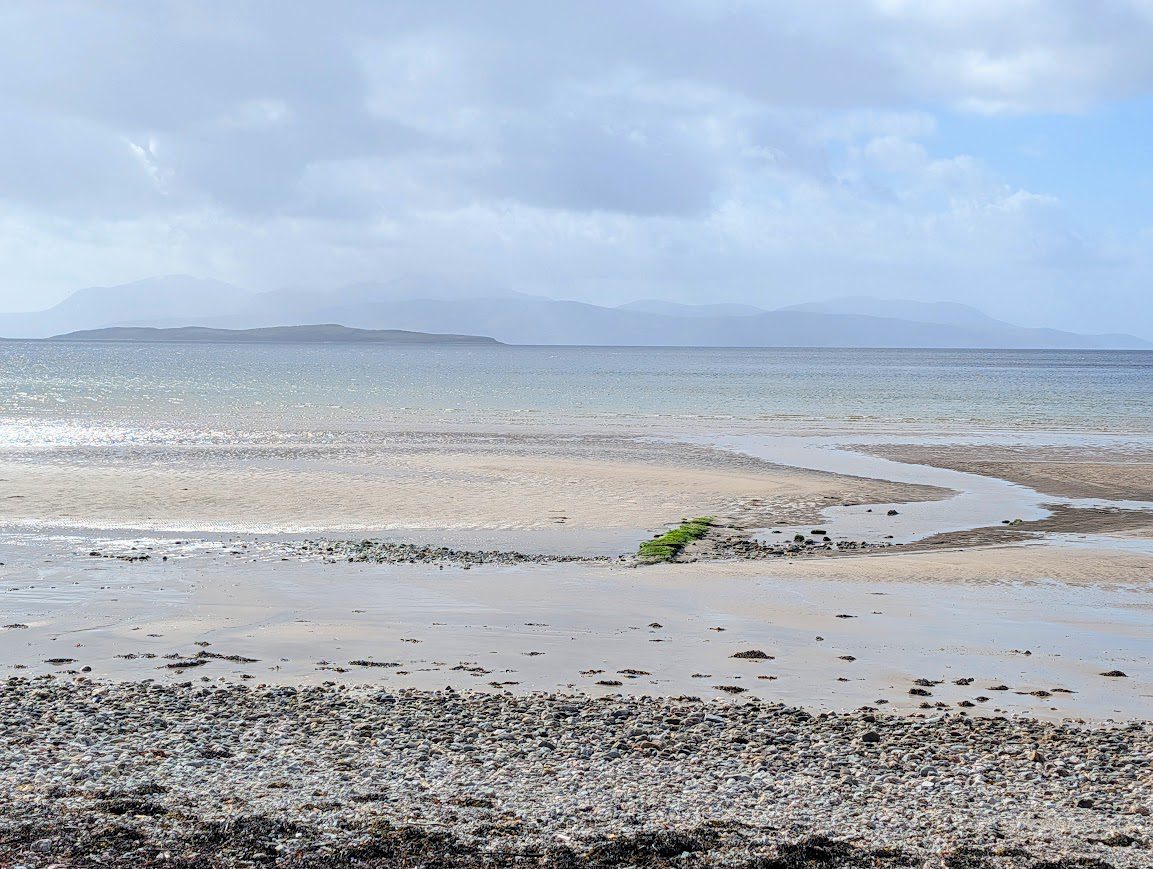 A pebble beach gives way to golden sands and turquoise water