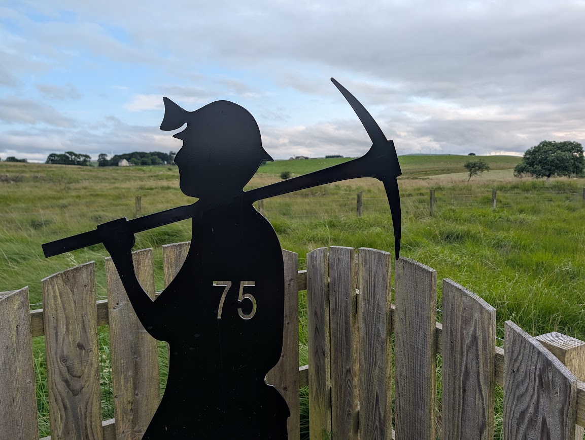 Metal sculpture in the silhouette of a mine worker with a tool over his shoulder
