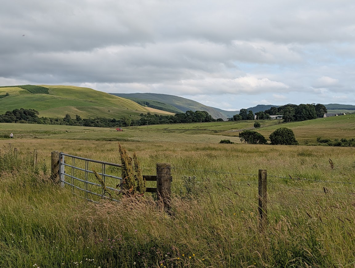 View across farmland to rolling green hills