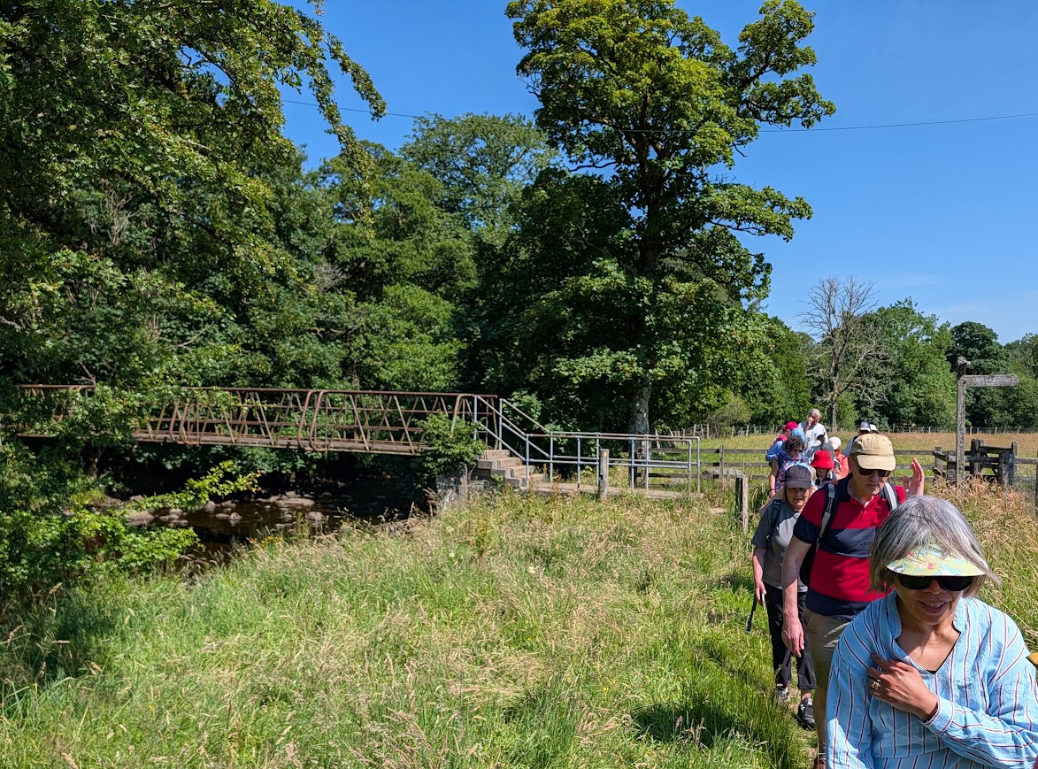 A group walking away from a large footbridge known as Danny's Bridge