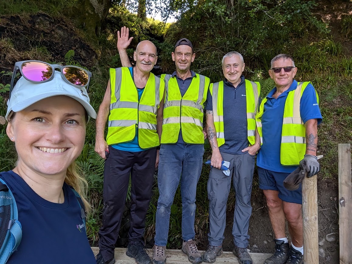 Gillian posing with 'The Auld Boys' in hi viz wasitcoats, on the paths network along the River Afton