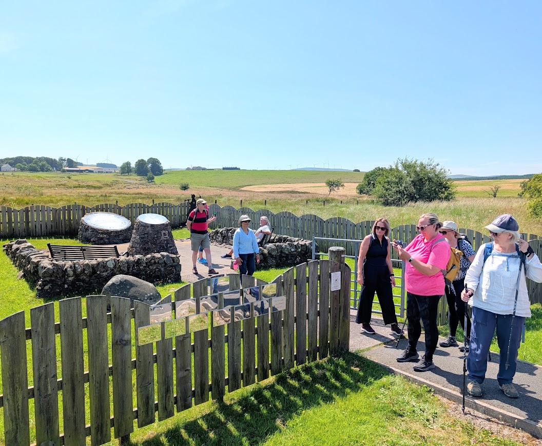 A group taking a pause at the Knockshinnoch Lagoons Disaster Memorial